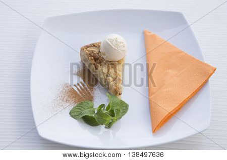 Apple pie dessert decorated with vanilla, mint and cinnamon .