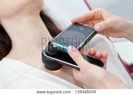 Doctor examining birthmarks and moles on a female patient (examination of birthmarks)