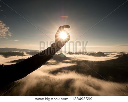 Man Hand Touch Sun. Misty Daybreak In A Beautiful Hills.