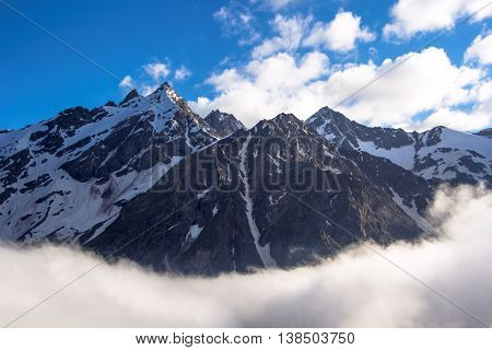 mountains, tops over clouds, the blue sky, a landscape