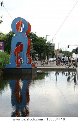 BERLIN, GERMANY - JUNE 21: Cyclists and pedestrians pass the sculpture Untitled Boxers 1987 by Keith Haring on June 21 2016 in Berlin.