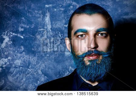 Dark portrait of a handsome man with blue beard. Folktale.