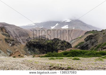 Icelandic landscape with red hills and black rocks in Lonsoraefi