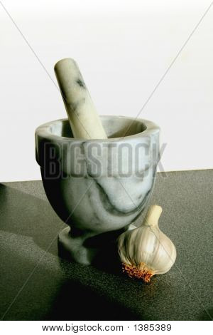 Pestello e mortaio con bulbo d'aglio