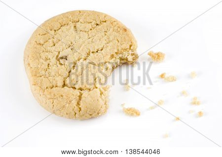 Stem ginger cookie with a bite out of it on a white background