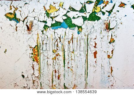 Grunge wall with cracks and peeling paint in old house. White textured background
