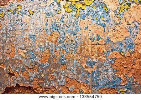 Grunge wall with cracks and peeling paint in old house. Textured background