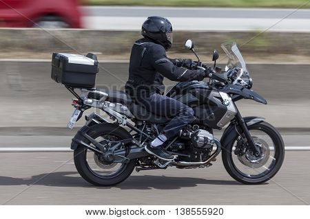 FRANKFURT GERMANY - JULY 12 2016: Motorcyclist on the BMW R1200 GS motorcycle driving on the highway in Germany