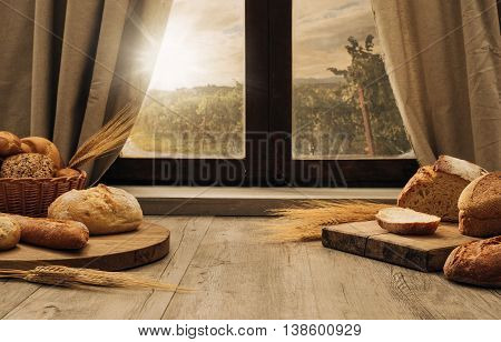 Freshly baked bread on a chopping board on the kitchen table in front of a window healthy eating concept