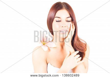Beautiful woman with lily looking down and toching her cheek. SPA treatment.