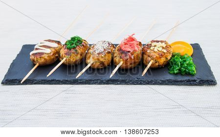 Japanese skewers of chicken with soy sauce and sesame seeds.