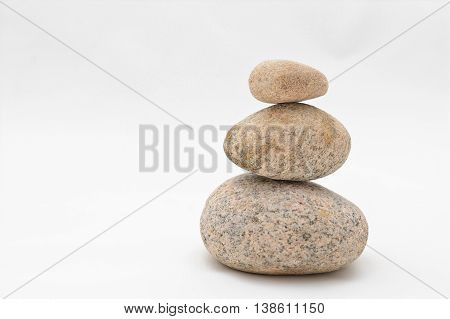 Pyramid of three stones isolated on white background
