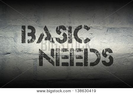 basic needs stencil print on the grunge white brick wall