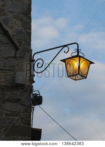 Vintage street lamp in medieval village at twilight. Tuscany Italy