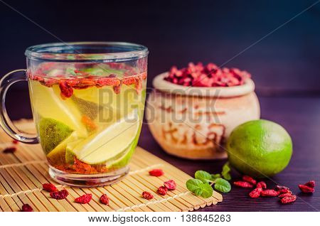 Fresh antioxidant herbal tea from goji berries and lime in glass cup. Wolfberry for a healthy diet. Healthy food. Alternative medicine. Recovery. Rejuvenation. Slimming. Selective Focus.