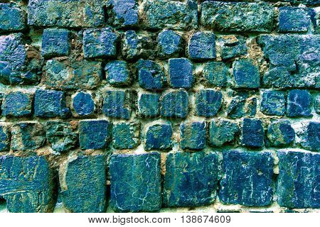Old corroded wall made from blue slag (Cinder) stones