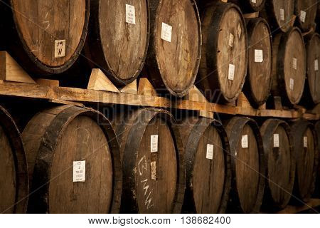 Wine barrels stacked in the old cellar of the winery.