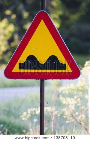 a warning sign saying that the road is bumpy