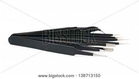 Pile of black metal anti-static tweezers tools isolated over the white background