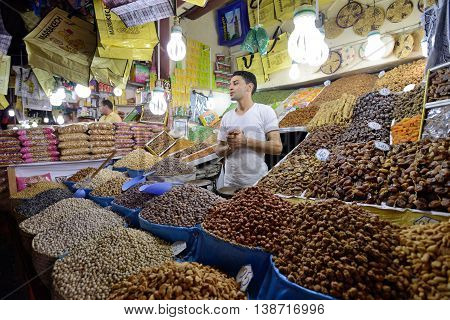 MARRAKESH - JULY 09: Unknown man trades a dried fruits in a market (souk), July 09, 2013 in a Marrakesh, Morocco. The market is one of the most important attractions of the city Marrakesh, Morocco