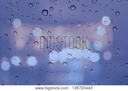 Glass window with a background bokeh and drizzle.