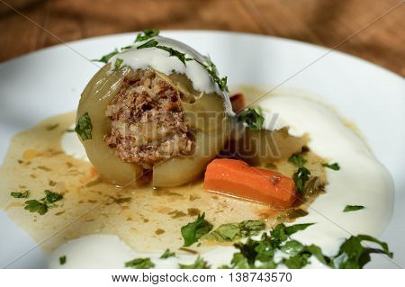 Stuffed peppers - traditional dish for some of the countries in Eastern Europe and Central Asia. Sweet paper stuffed with minced meet rice and herbs served with gravy and sour cream. Matte filter Shallow DOF.