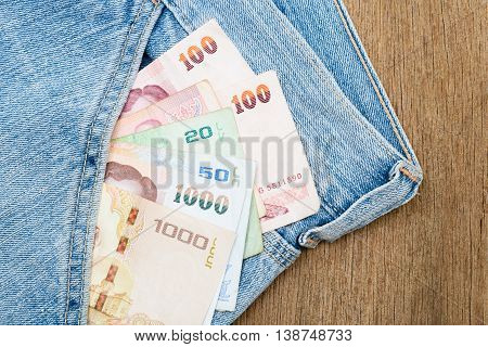 Close up of Thai baht banknotes in jeans pocket.