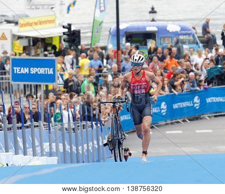 STOCKHOLM - JUL 02 2016: Leading triathlete Flora Duffy running with cycle in the transition zone in the Women's ITU World Triathlon series event July 02 2016 in Stockholm Sweden