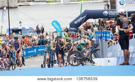 STOCKHOLM - JUL 02 2016: Group of triathletes running with cycles in the transition zone in the Women's ITU World Triathlon series event July 02 2016 in Stockholm Sweden