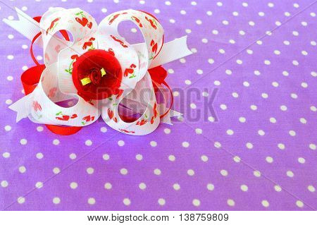 Bright bow of ribbon on fabric background with copy space. Beautiful accessory for girls. Hair decoration