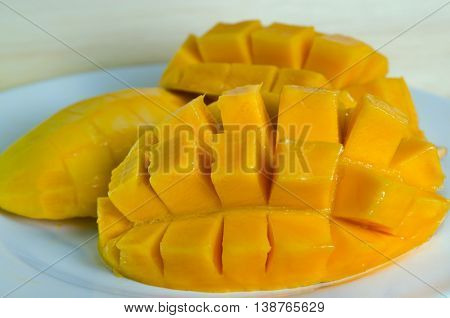 Mango ripe with nicely cut pieceson the plate on wooden board (Other names are horse mango Mangifera foetida Anacardiaceae Mangifera M. indica)