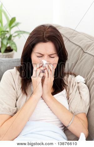 自宅でソファの上で彼女の鼻を吹く病気の女性の肖像画