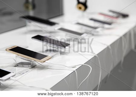New smartphones on a white showcase with antitheft system