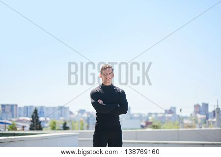 Portrait of a male athlete on the background of the city