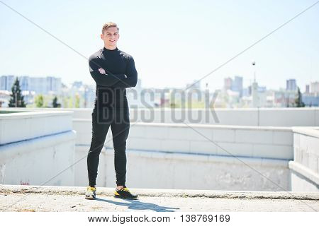 Portrait of a male athlete on the background of the city