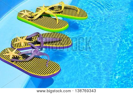 Flip flops on the swimming blue pool.