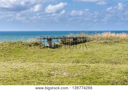 Danmark coastline with wooden bench and cloudy sky