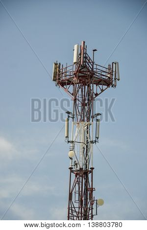 Base transceiver station (BTS) with antenna isolated on blue sky background. Telecommunications radio tower cells