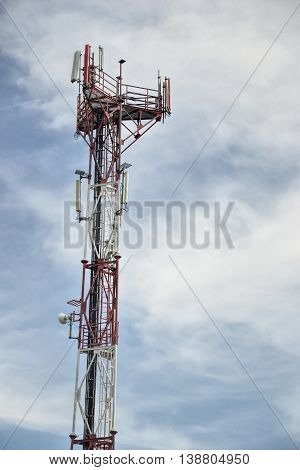 Base transceiver station (BTS) with antenna isolated on blue sky background. Telecommunications radio tower cells