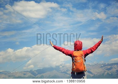 young woman hiker open arms at beautiful mountain trail