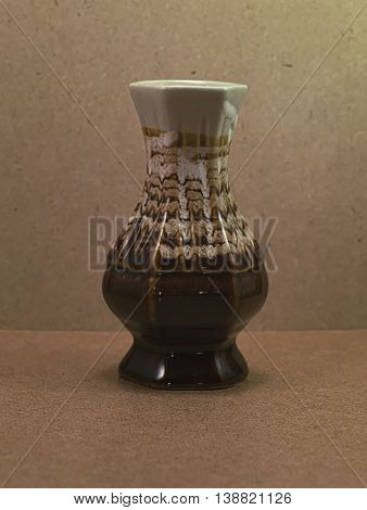 Beautiful vintage brown ceramic vase on wooden board