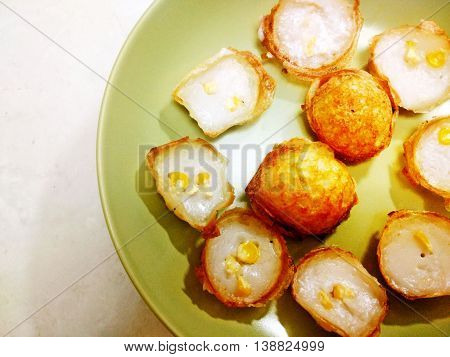kanom krok or thai coconut pudding on a green ceramic dish