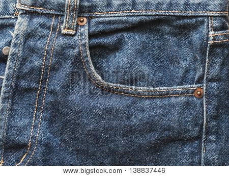 Close up old faded blue jeans pocket