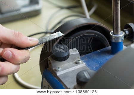sharpen a chisel with a wet grinder - closeup