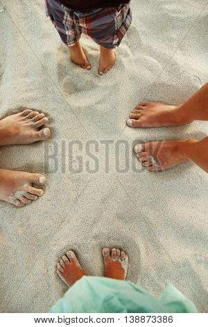 Family feet on the sand on the beach