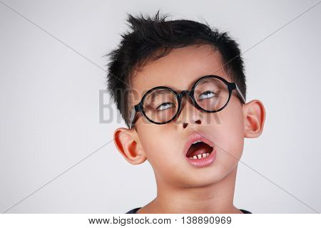 Portrait of Asian boy with glasses showing very lazy unhappy bored and tired gesture