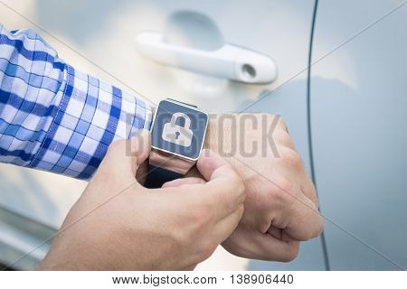 Close up shoot of male hands locking the car doors by using smart watch remote control security app.