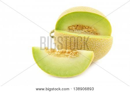 fresh galia melon and a cut piece on a white background
