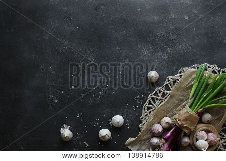 purple spring onions on dark table background