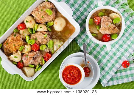 oven baked chicken things new potatoes tomatoes and butter lima bean in graten dish and in soup bowl on table mat view from above
